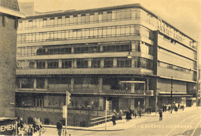 1266 Gezicht op de zij- en voorgevel van Galeries Modernes (Oudegracht, hoek Lange Viestraat) te Utrecht met op de ...